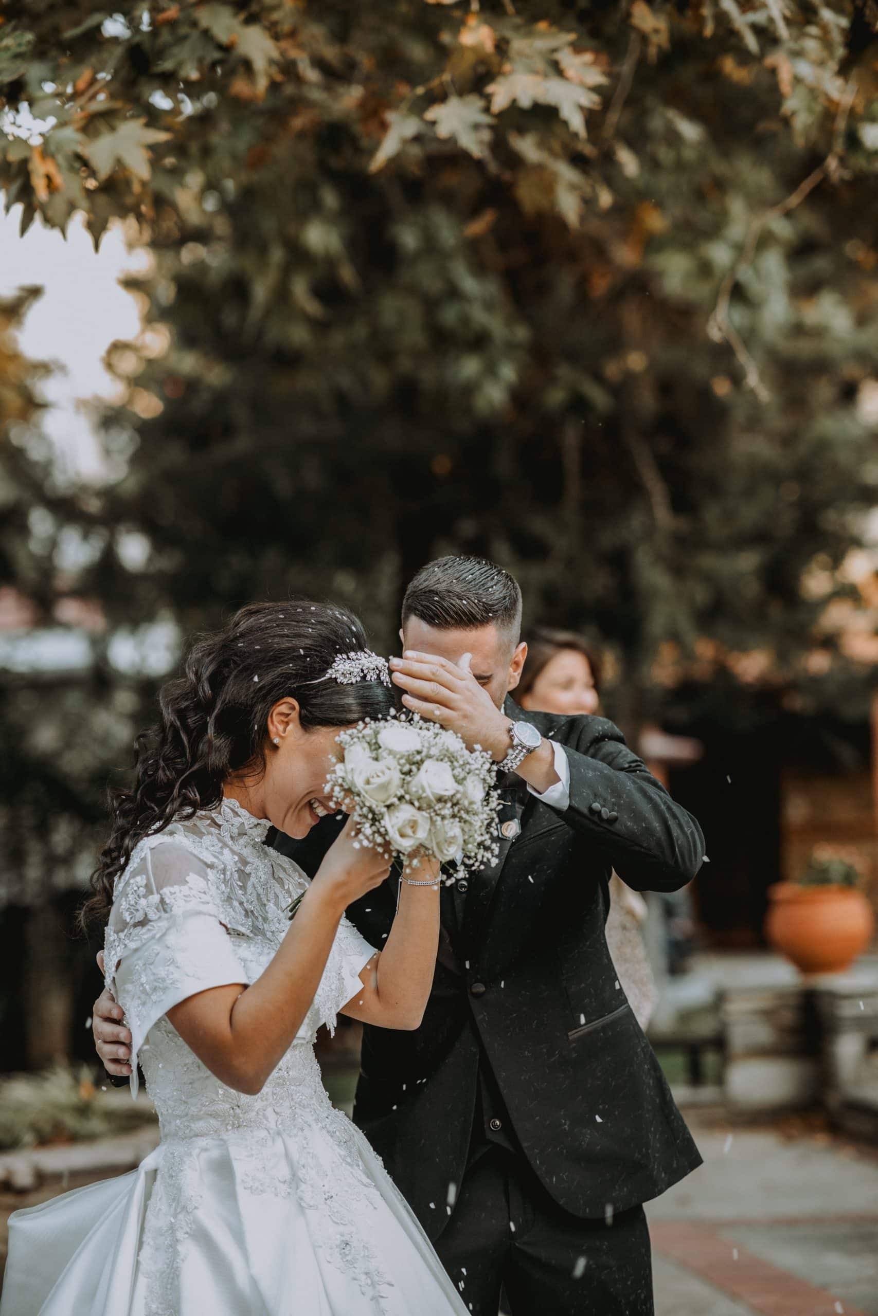 ζευγάρι φωτογραφία γάμου φωτογράφος  next day φωτογραφιση φωτογράφηση γάμος θεσσαλονίκη θεσσαλονικη νεονυμφοι που κοιτιούνται δάσος φύση κρυμμένοι πίσω απο την ανθοδέσμη για να προφυλαχθούν απο το ρύζι, μια ρομαντική, αστεία και συγκινητική εικόνα , φωτογράφος γάμου Γιώργος Καρασαββίδης Θεσσαλονίκη